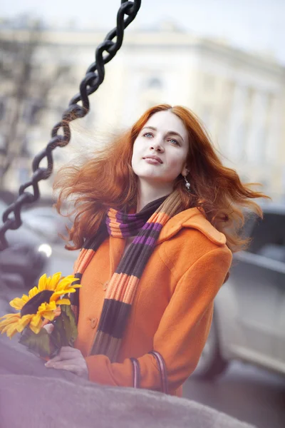 Hübsches Mädchen, das mit einer Sonnenblumenstadt geht — Stockfoto