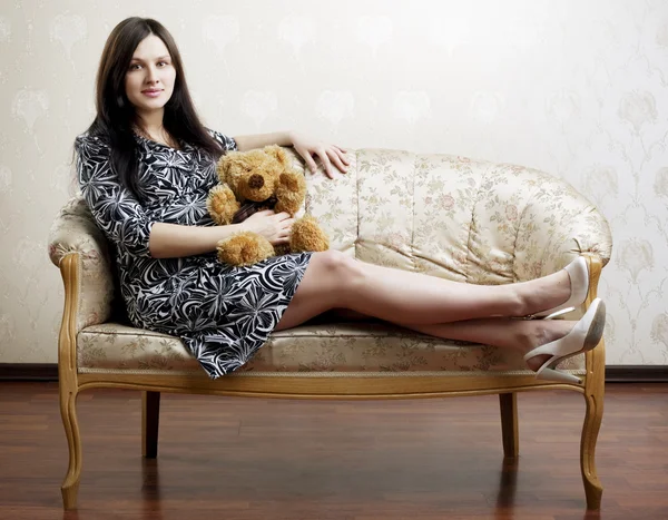Беременная женщина сидит на винтажном диване — стоковое фото
