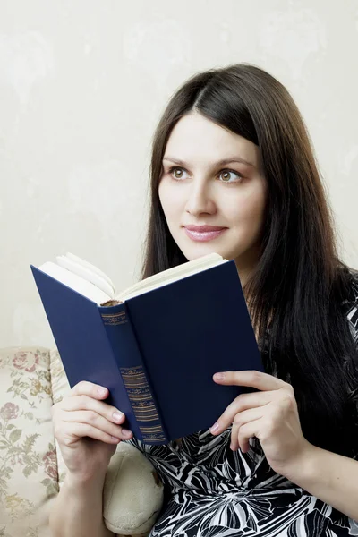 stock image Woman, who reads book sitting on the sofa