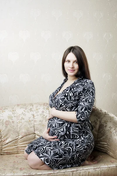 Těhotná žena na vinobraní gauči — Stock fotografie