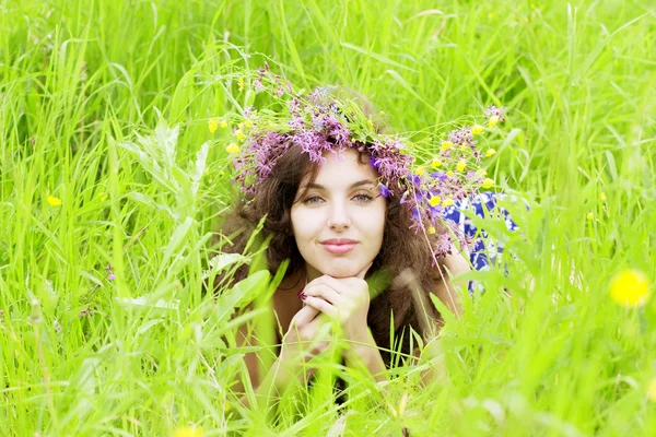 Fille portant une couronne de fleurs sauvages dans le champ Image En Vente