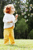 Mädchen legt die Blasen in den Park