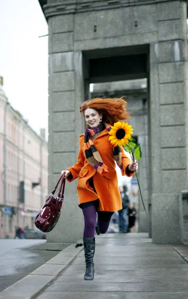 Mooi meisje lopen met een zonnebloem stad — Stockfoto