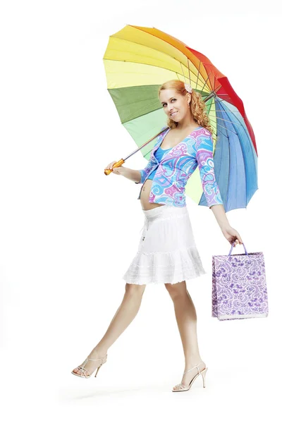 Schöne schwangere Mädchen mit einem Regenbogen-Regenschirm — Stockfoto