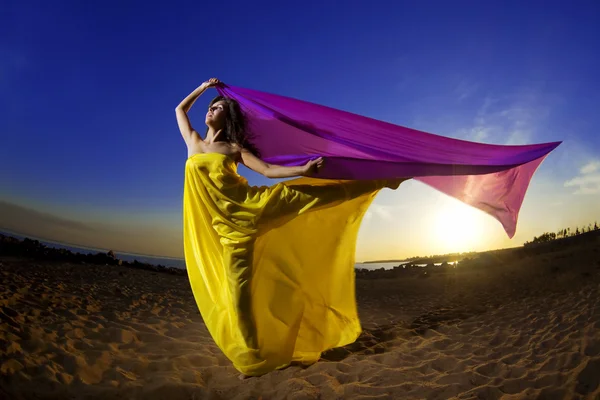 Mädchen am Strand wächst Gewebe auf einem Hintergrund der Sonne. — Stockfoto