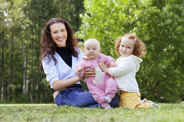 Mamma med två barn på fältet — Stockfoto