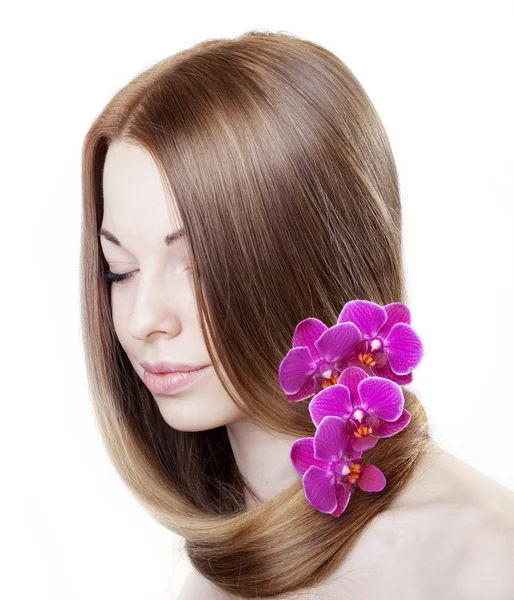 Menina bonita com orquídeas em seu cabelo lindo — Fotografia de Stock
