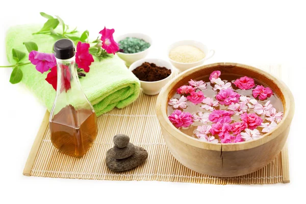 Spa thérapie, fleurs dans l'eau, sur un tapis de bambou . — Photo