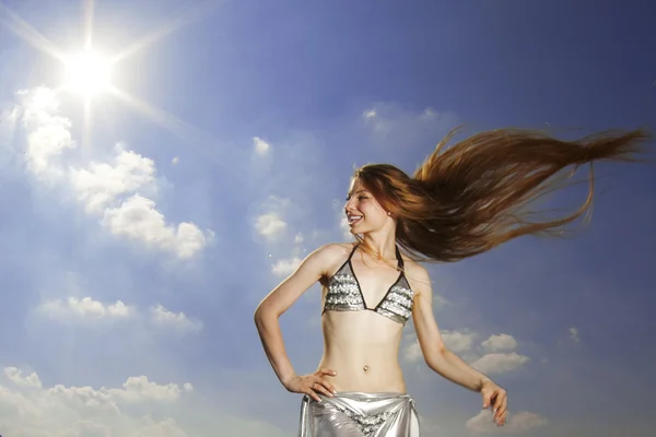 Flicka med långt hår mot himlen — Stockfoto