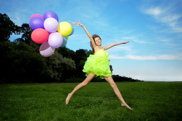 Mujer sosteniendo racimo de globos de aire de colores —  Fotos de Stock