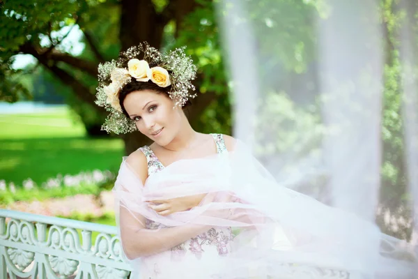 Mooie vrouw met een krans van rozen — Stockfoto