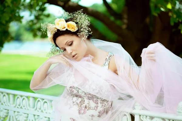 Mulher bonita com uma coroa de rosas — Fotografia de Stock