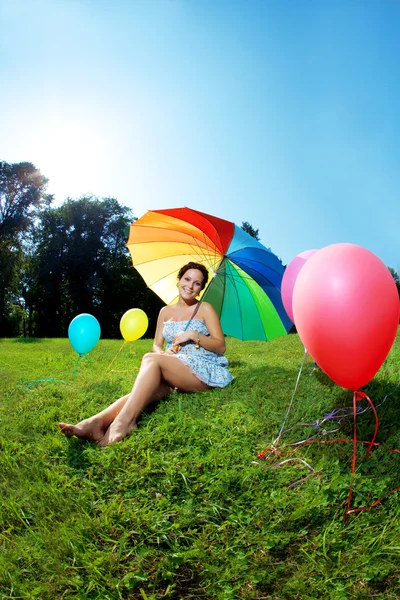 Zwangere vrouw regenboog paraplu — Stockfoto