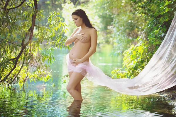Красивая беременная девушка на открытом воздухе — стоковое фото