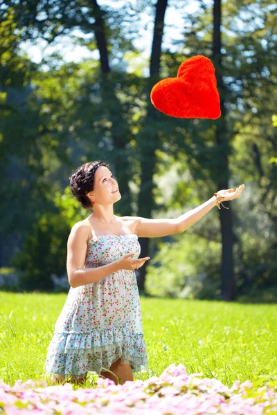 Krásná těhotná žena s červeným srdcem — Stock fotografie