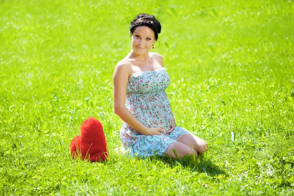 Mulher grávida bonita com um coração — Fotografia de Stock