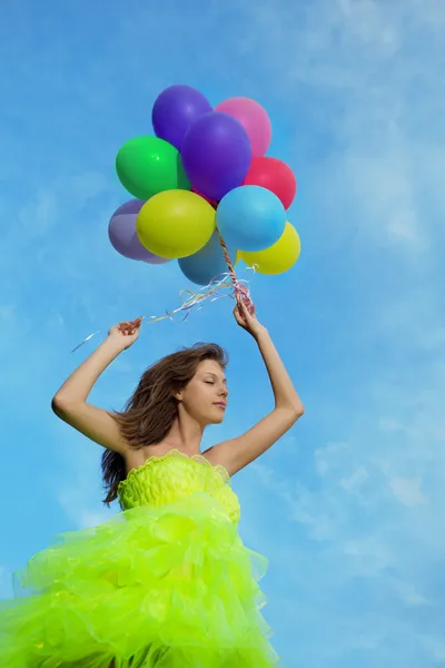 Жінка тримає купу барвистих повітряних кульок — стокове фото