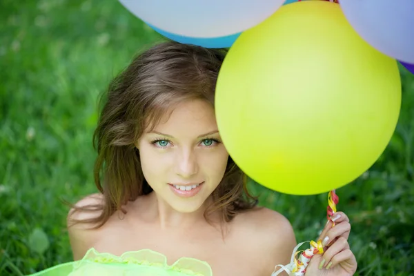 Frau hält Bündel bunter Luftballons in der Hand — Stockfoto