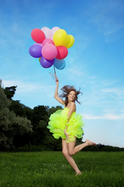 Žena držící banda barevné balónů — Stock fotografie