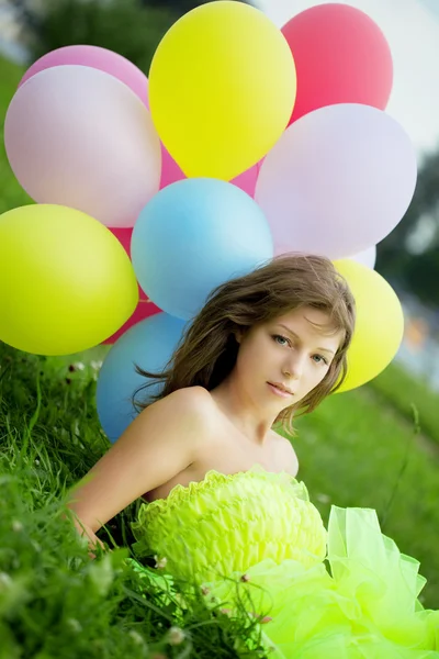 Жінка тримає купу барвистих повітряних кульок — стокове фото