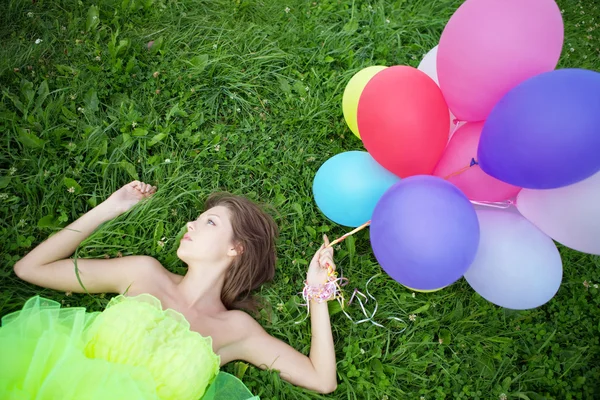 Woman holding bunch of colorful air balloons — Stock Photo, Image