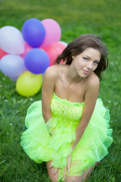 Mujer sosteniendo racimo de globos de aire de colores — Foto de Stock