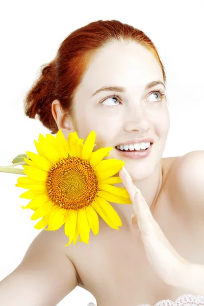 Schönes lächelndes Mädchen mit einer Sonnenblume in den Händen — Stockfoto
