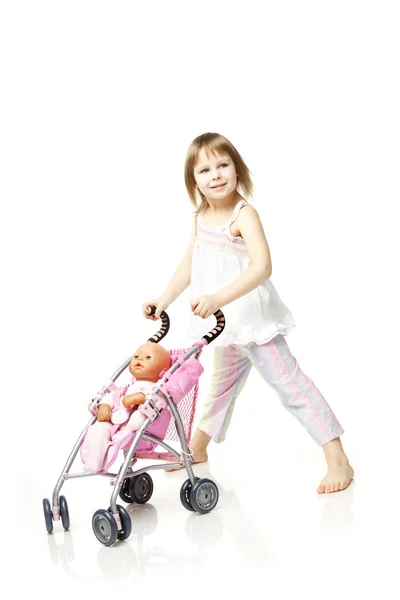 Маленька дівчинка з лялькою в колясці — стокове фото