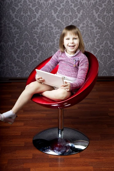 Κορίτσι που κάθεται σε μια καρέκλα με ένα φορητό υπολογιστή — Φωτογραφία Αρχείου