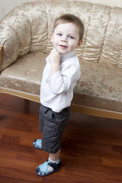 Симпатичный маленький мальчик на фоне винтажного дивана — стоковое фото