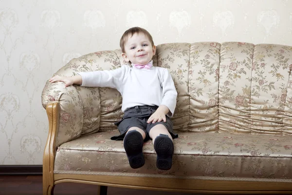 Cute little boy on a background of vintage sofa — Stock Photo, Image