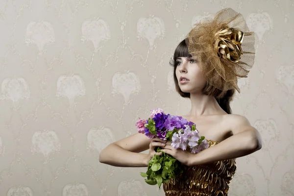 Luxuriöses Mädchen mit Blumen in den Händen — Stockfoto