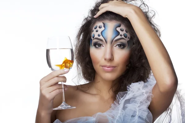 Mädchen mit Make-up, mit einem Fisch im Glas in der Hand — Stockfoto