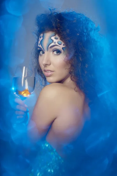 Dziewczyna z makijażem, z rybą w szklance w dłoni — Zdjęcie stockowe