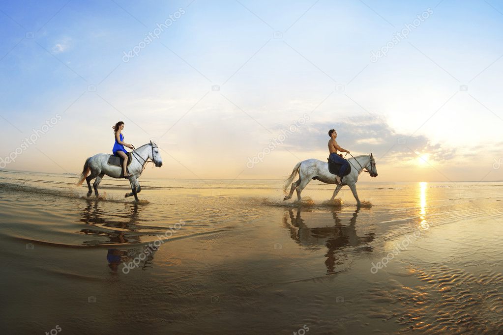 Couple in love, which is galloping on a horse of the sea at suns