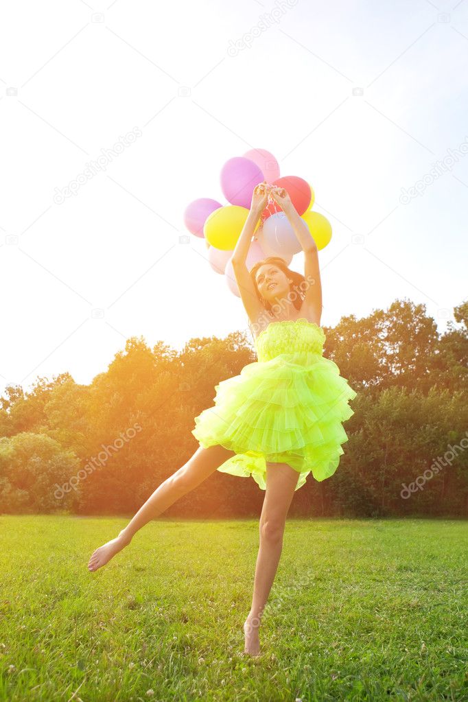 Woman holding bunch of colorful air balloons