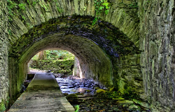HDR - річка, що протікає через кам'яні тунелі — стокове фото