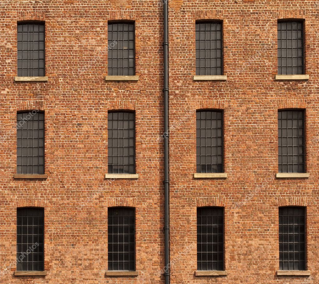 Old Orange Brick Wall with Twelve Windows and Gutter Stock Photo by