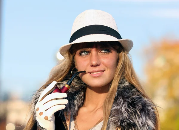 Молода дівчина курить трубу на природі — стокове фото