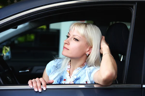 Porträtt av unga vackra attraktiv kvinna sitter i bil. — Stockfoto