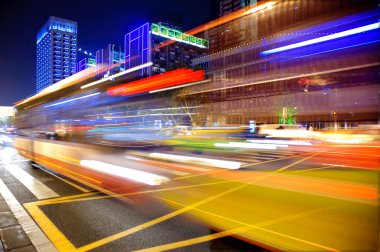 High speed and blurred bus light trails in downtown clipart