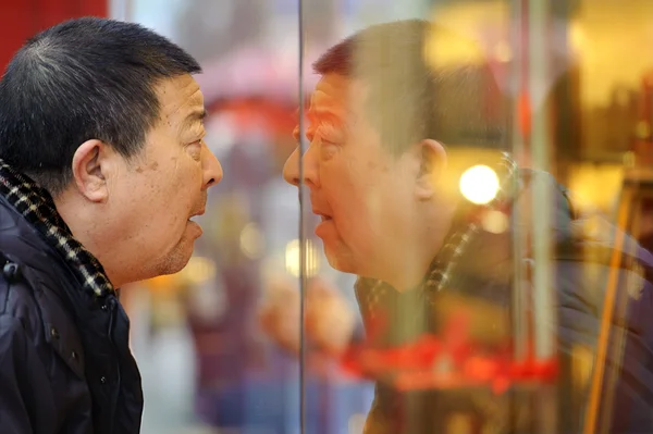 바쁜 쇼핑 거리에 골드 쇼핑 창에서 보는 남자 중지 — 스톡 사진