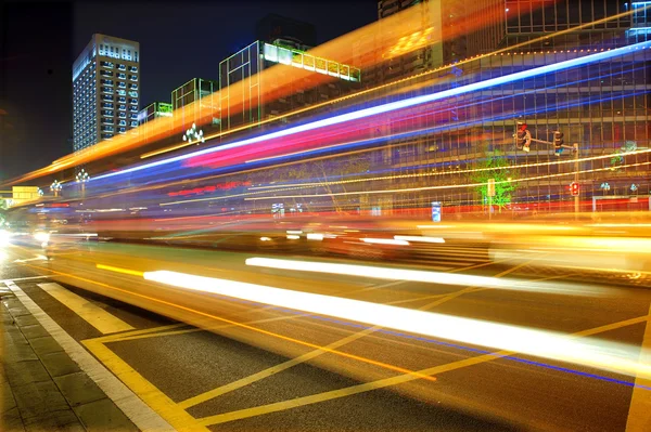 高速、都心の夜景でぼやけたバス光の道 — ストック写真