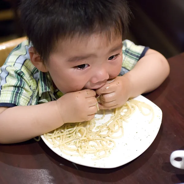 Eten baby om te grijpen pasta — Stockfoto