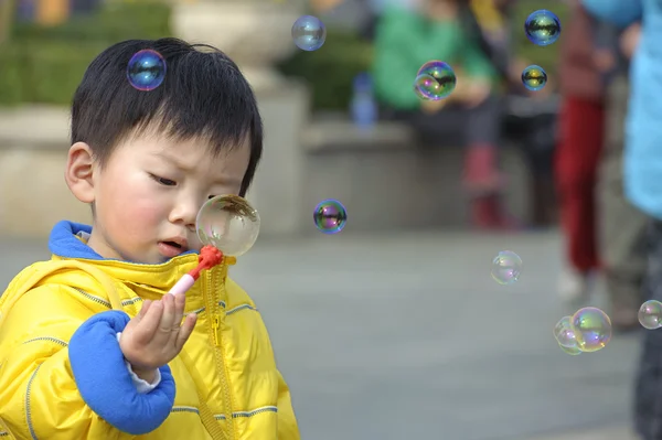 Kind pustet Seifenblasen — Stockfoto