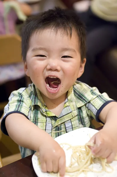 Comer bebê para pegar macarrão e riu — Fotografia de Stock