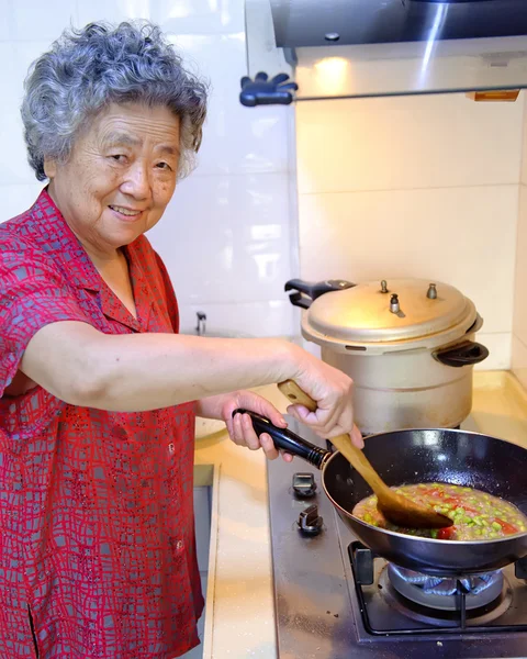 Une grand-mère cuisine dans la cuisine — Photo