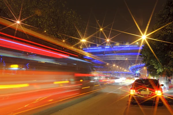 Θολή μονοπάτια οχήματα μεγάλης ταχύτητας σε αστικές οδούς κάτω από αερογέφυρα — Φωτογραφία Αρχείου
