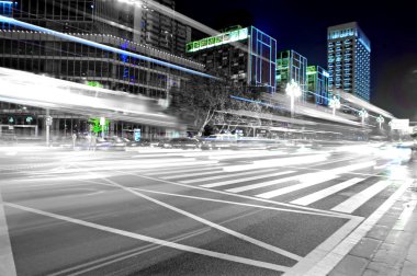 High speed and blurred bus light trails in downtown nightscape clipart