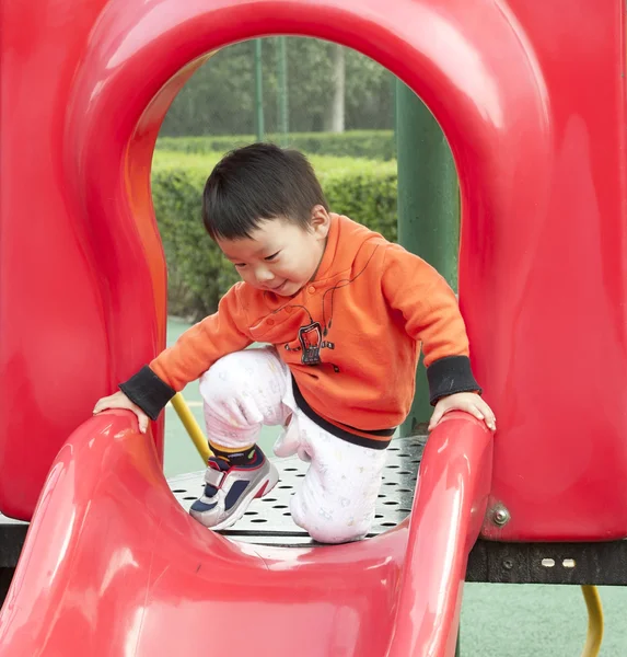 Baby playing on sliding board — Stock Photo, Image